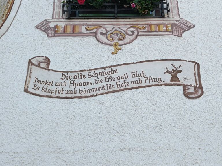 Gemaltes Schriftband an der Fassade der Alten Schmiede in Sistrans